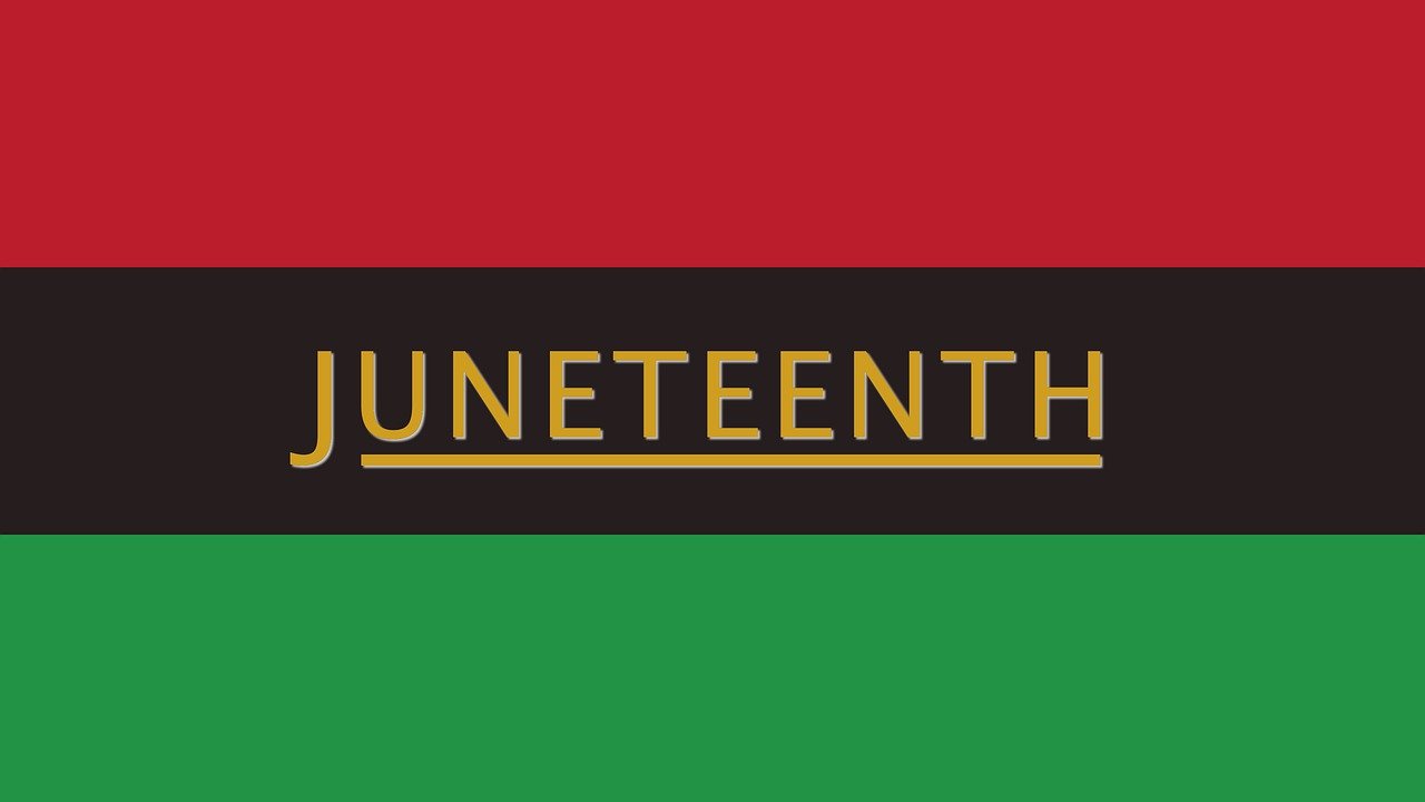 a flag with three horizontal color blocks. the top is red, the middle is black, and the bottom is green. "JUNETEENTH" is written and underlined in yellow text against the black section.