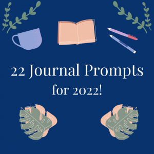 "22 Journal Prompts for 2022!" written in white text against a dark blue background. Surrounding the text are images of a purple cup with a handle, an open book, two pens, and green leaves