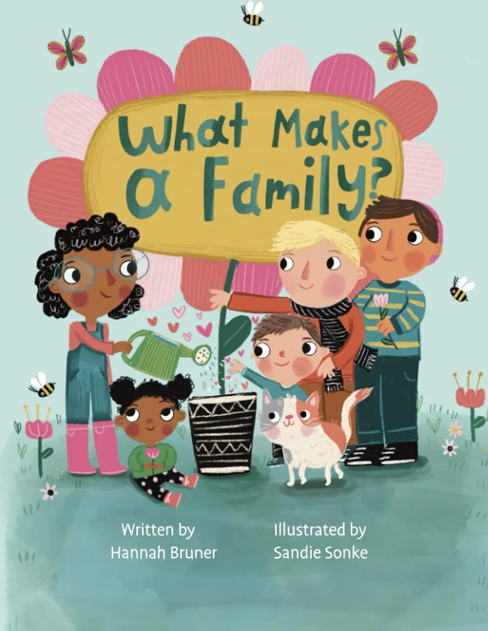 Book cover for "What Makes a Family," written by Hannah Bruner. The title is written in green text in the yellow center of a flower with petals of different shades of pink. A family of two waters the flower on its left side, while a family of four (including a pet cat) holds the flower on its right side.