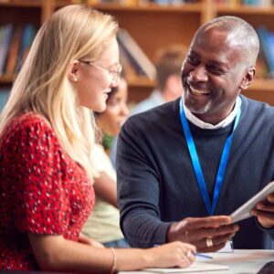Image of a Black man and a White woman smiling and talking