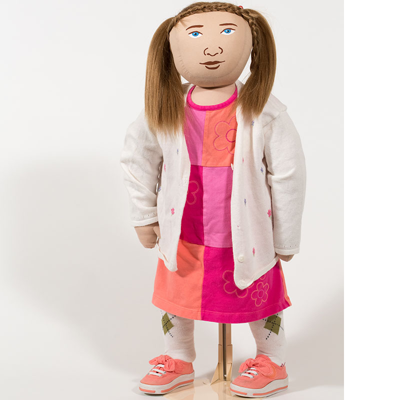 AmazeWorks Persona Doll, Madison, wearing a pink and red floral dress, a white cardigan, and pigtails
