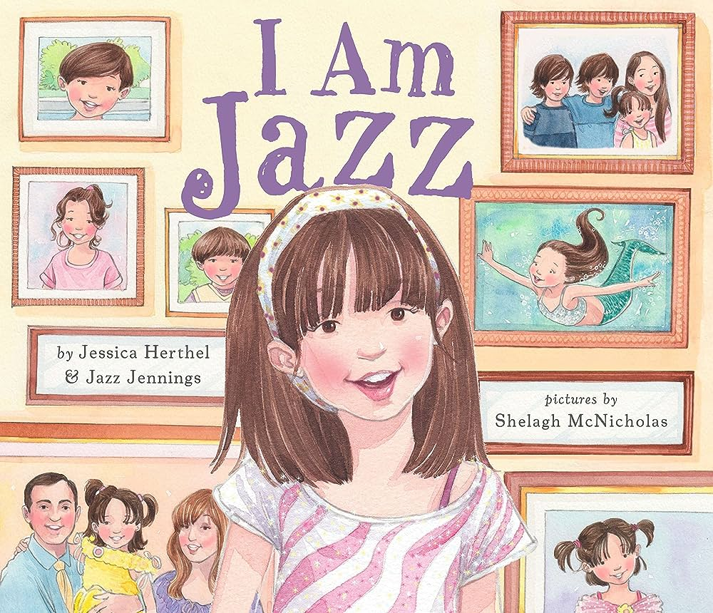 Book cover for "I Am Jazz," featuring a young girl with straight brown hair with bangs. She wears a shirt with pink and white zebra print. She is standing in front of a wall of framed family photos.