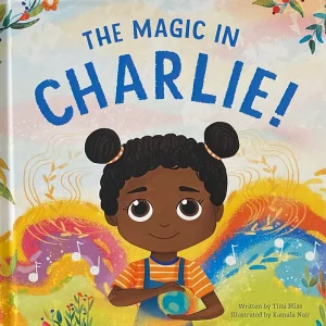 Book cover for The Magic in Charlie! featuring a young Black child with her hair in two buns atop her head. She is smiling wearing an orange striped shirt and blue overalls. She stands in front of a colorful background.