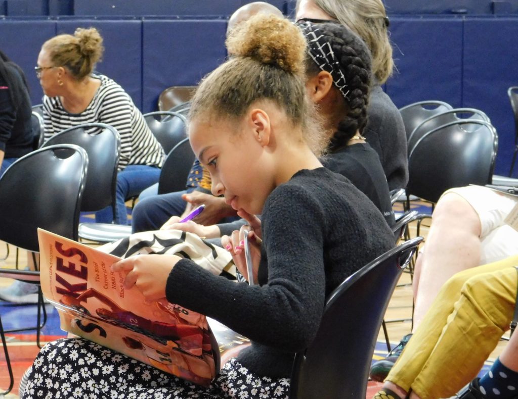 Sojourner Truth Academy scholar reads a copy of STOKES