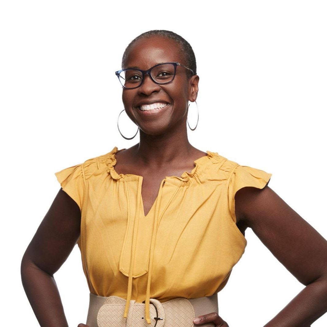 Headshot of Nyia Harris, a Black woman with very short hair, wearing glasses, hoop earrings, and a yellow dress