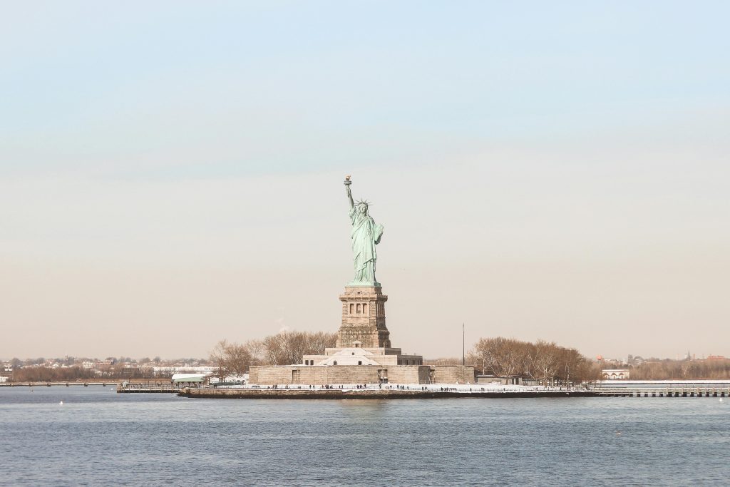 Overlooking the Hudson River, the Statue of Liberty stands in the distance.