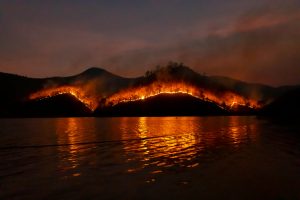 Overlooking the water is a wildfire in the distance