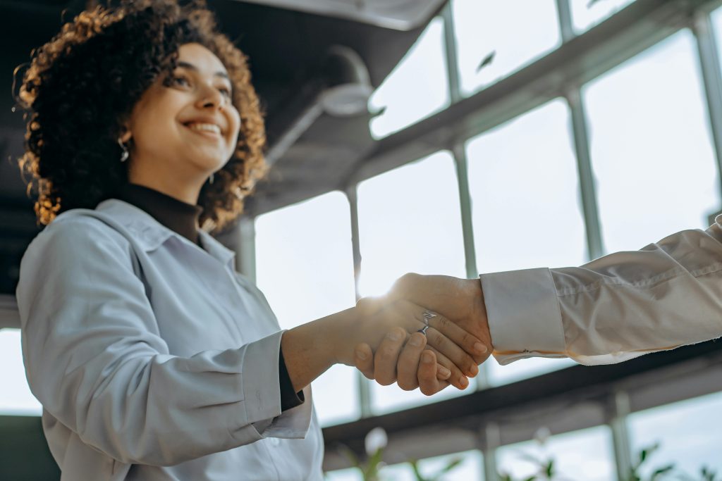 A woman shakes hand with someone off camera