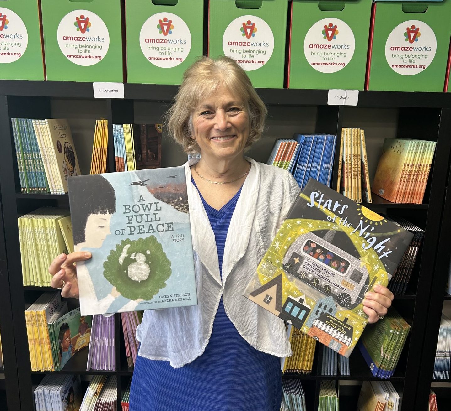Author Caren Stelson smiles while holding her two picture books, A Bowl Full of Peace and Stars of the Night.