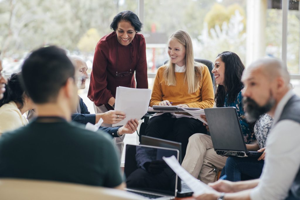 A group of employees sit around a table collaborating