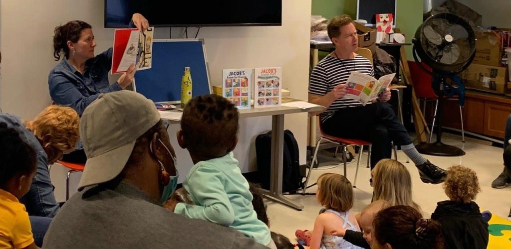 Sarah and Ian Hoffman read "Jacob's New Dress" to a room of children and families