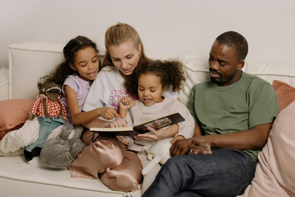 A family of four reads together on a couch
