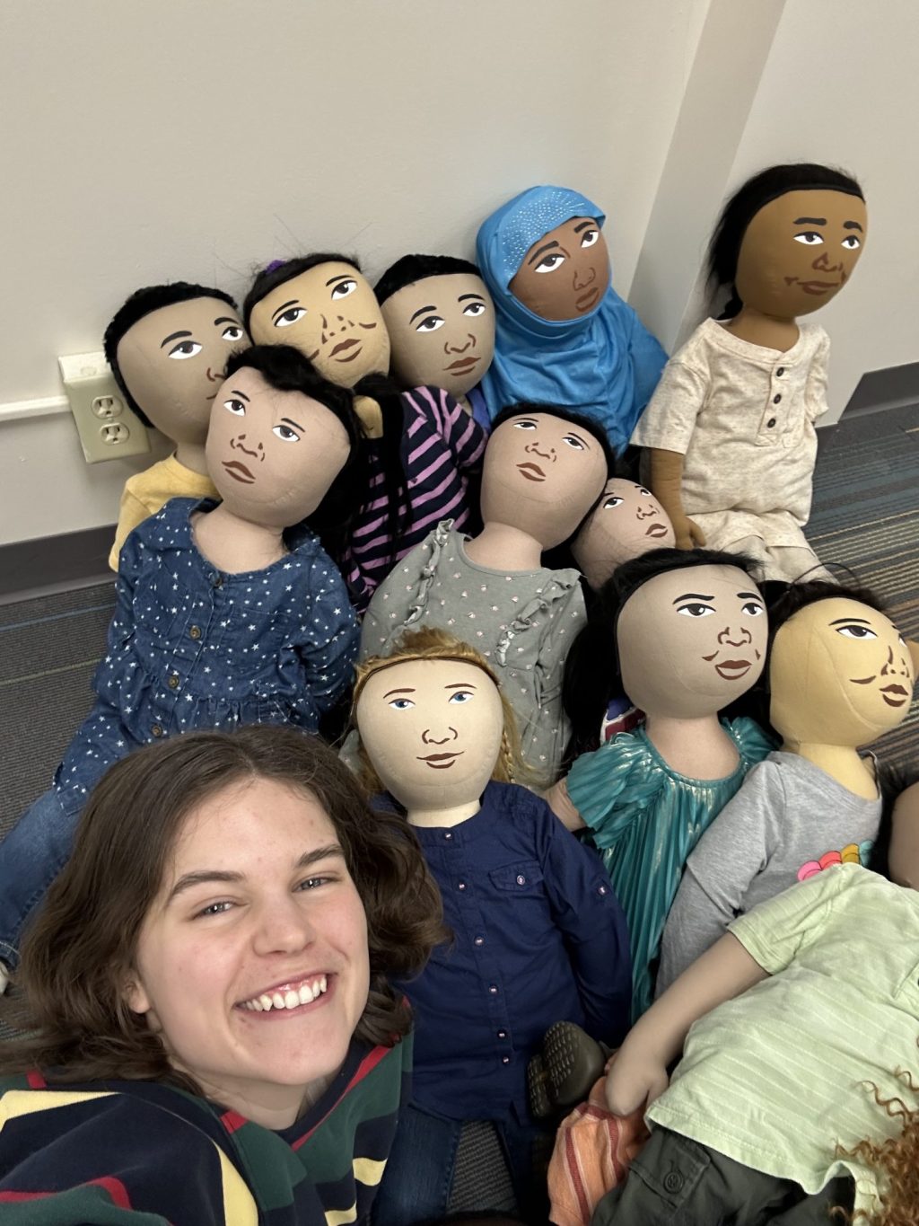 Sophie posing with a pile of persona dolls