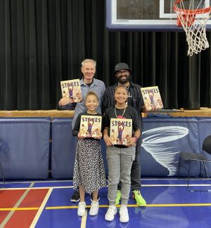 John Coy and Ty Chapman pose with two Sojourner Truth Academy students, holding copies of their indie press book, STOKES
