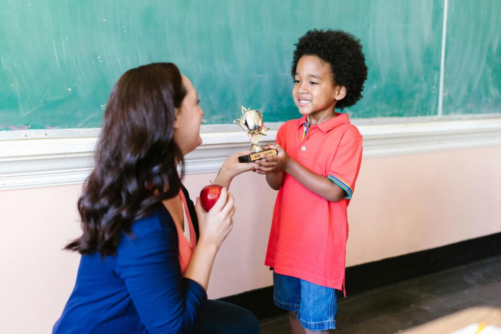 A student gifts his teacher a trophy