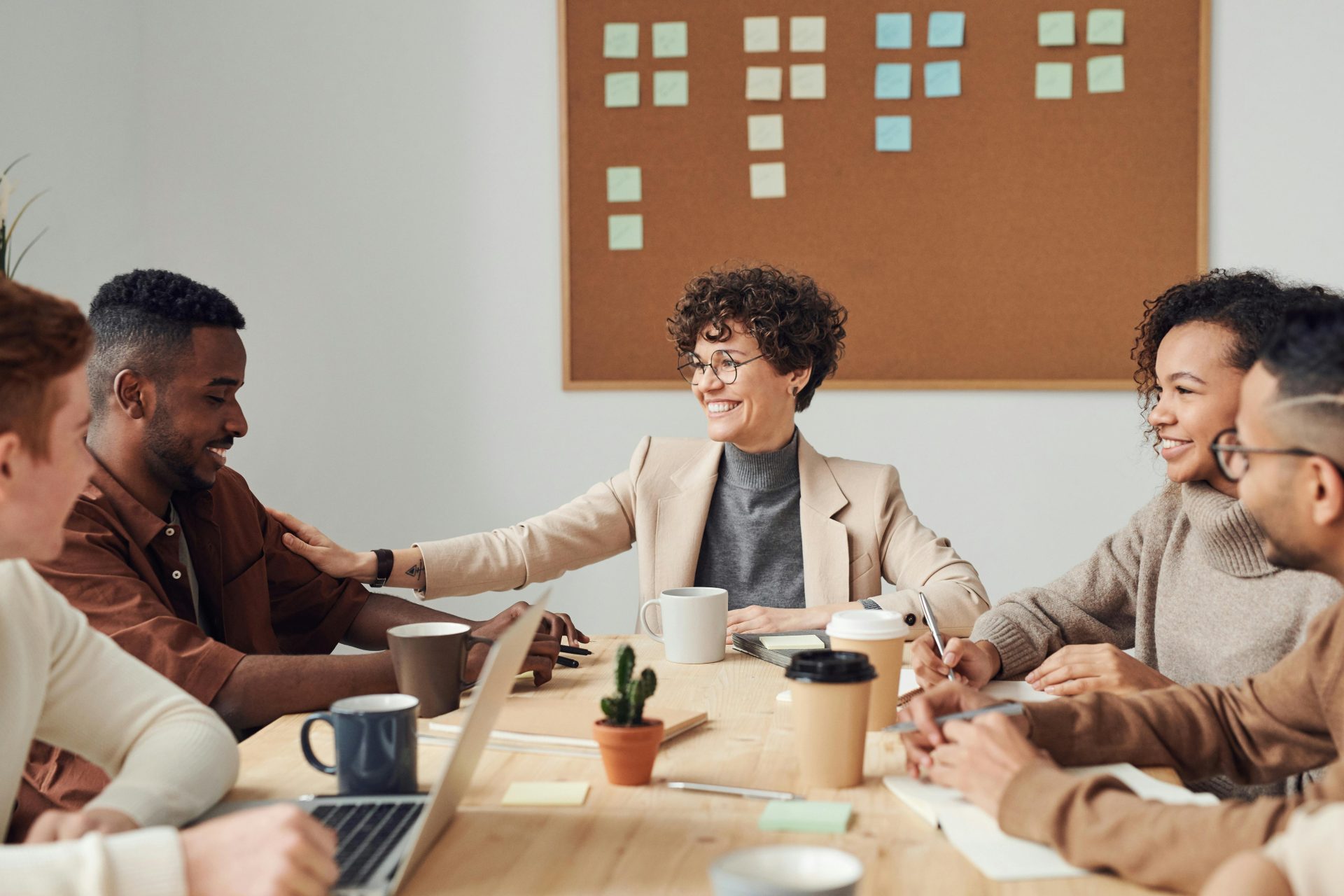 work team smiling while sitting around a table