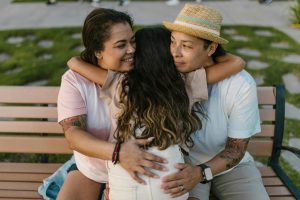 two moms hugging their kid
